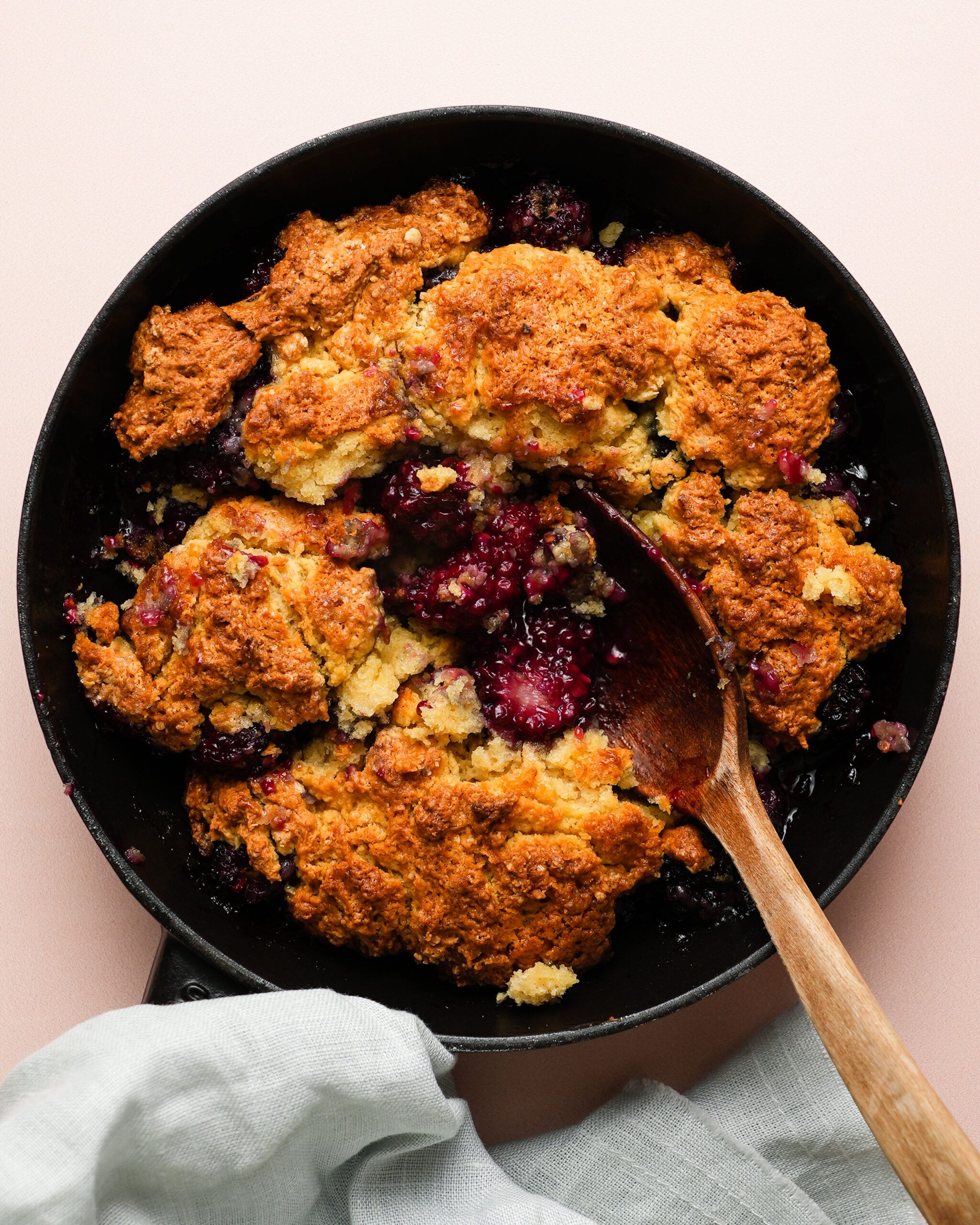 A fresh blackberry cobbler sits at the center of the image.